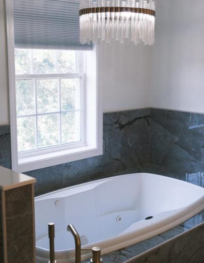Elegant bathtub with small chandelier - interior designer Salem NH