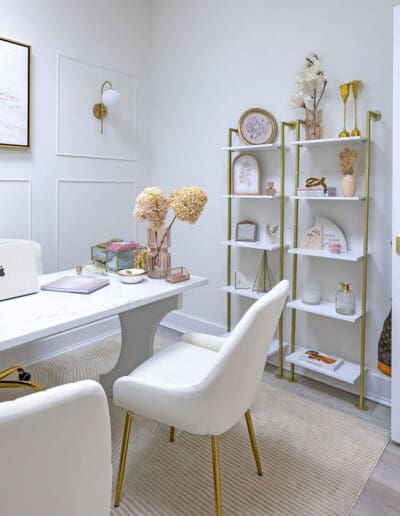 Modern white scheduling area with white desk and white and golden shelves - interior designer Nashua