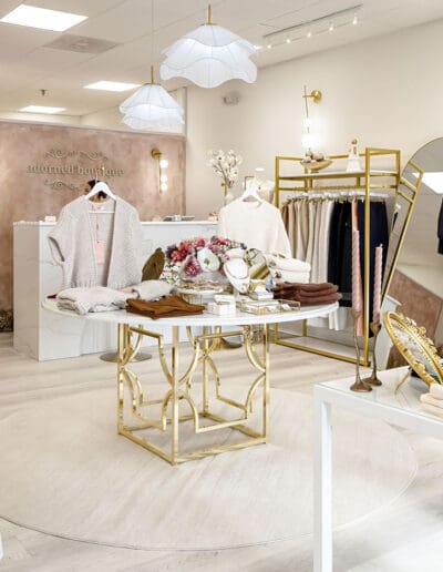 Modern white clothing shop with golden accents - interior designer Merrimack NH