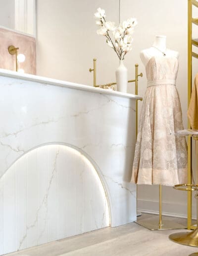 Modern boutique with marble table and mannequin with dress - interior designers eEeter