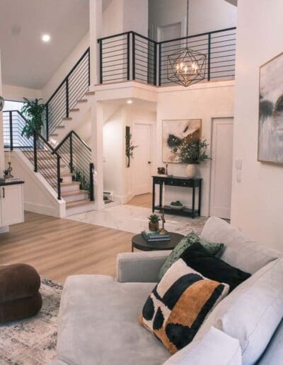 Modern living room with view to white staircase with black details - interior designer Nashua