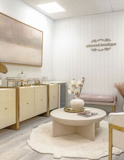 Adorned Boutique waiting area with decorative painting and console - interior designer Tyngsborough MA