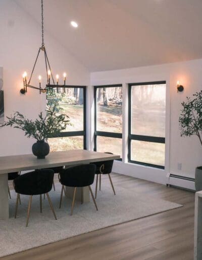 Modern white dining area with hanging lamps and green plants - interior designers Exeter