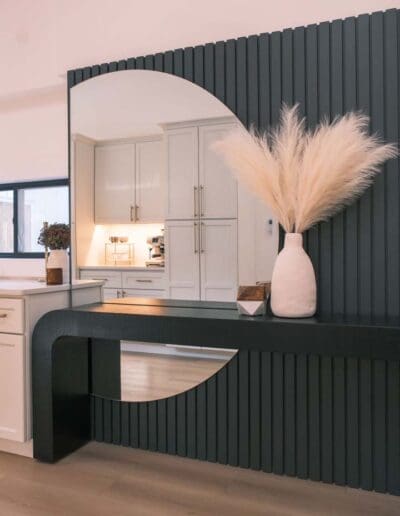 Modern entrance hall with green wall panels and abstract mirror - interior designer Salem NH