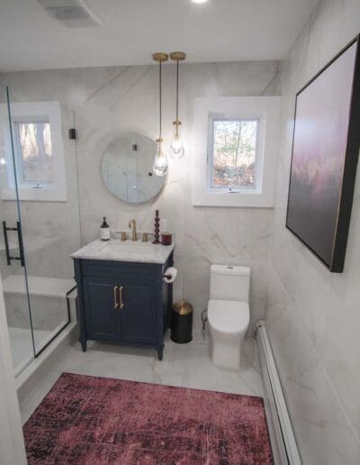 Modern bathroom with marble finish and blue furniture - interior designer Windham NH